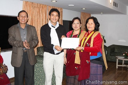 Chairman of CBTSUK Hon Lt Chandra Gurung presenting the cheque of Rs 633,770 to Chairperson of CBTS Ktm Ama Group Mrs Santu Ghale